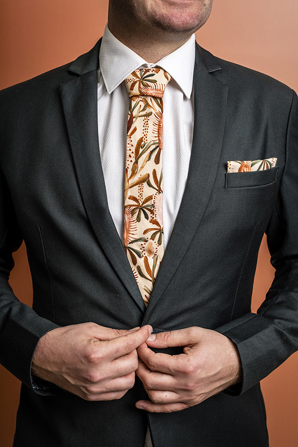 100% cotton tie showcasing a detailed Grass Tree motif in warm earthy hues, reflecting the beauty and toughness of Australian flora
