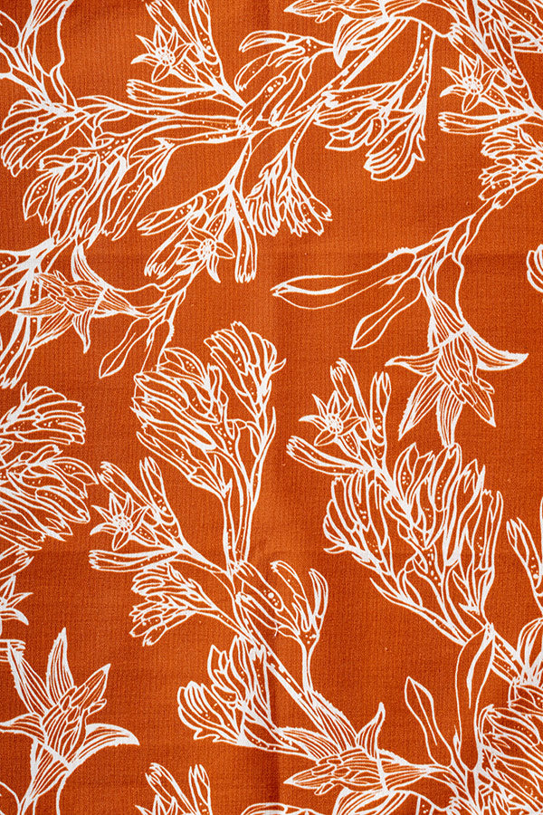 Intricate kangaroo paw floral print in burnt orange with delicate details and vibrant hues, showcasing Australian native flora