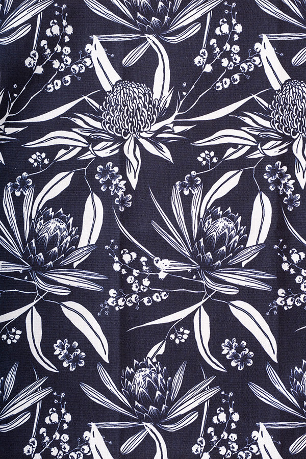 Intricate native Australian flora print featuring vibrant flowers and foliage, showcasing the beauty of local plant life in Navy and White colour way